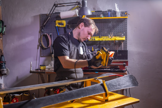 Un homme en tenue de travail, un réparateur de vêtements dans l'atelier, un service de ski réparant le ski